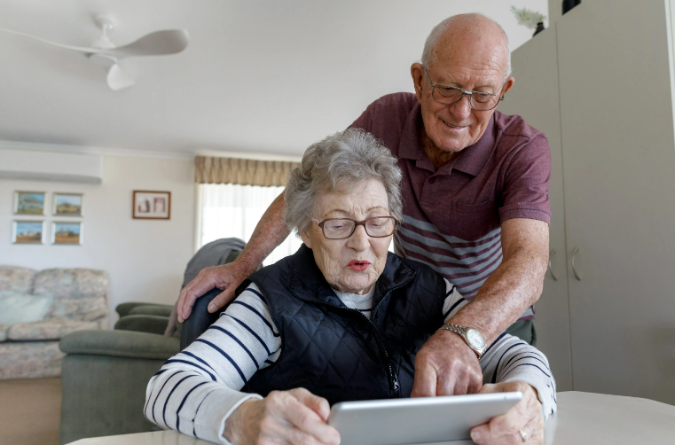 Two seniors reviewing information on a tablet.